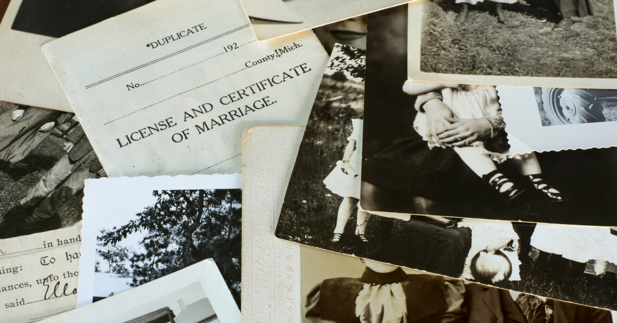 Old black and white photographs scattered on a desk